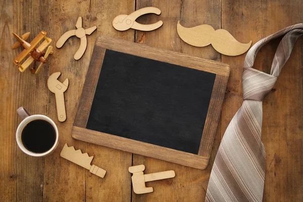 Top view image of fathers day composition with wooden shape tools, necktie , cup of coffee and blackboard — Stock Photo, Image