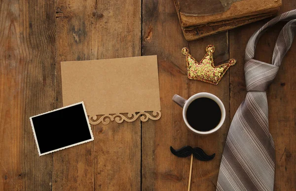 old books, glitter crown, necktie and cup of coffee. Father\'s day concept