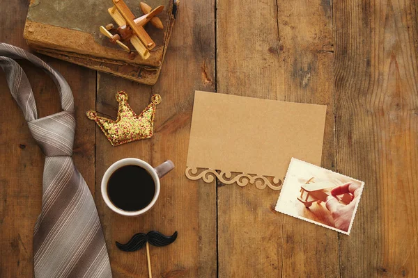 old books, glitter crown, necktie and cup of coffee. Father\'s day concept