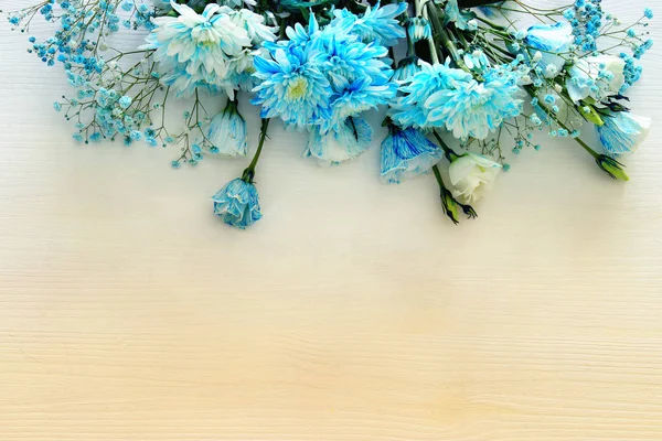 Schöne und zarte blaue Blumenarrangements auf weißem Holzhintergrund — Stockfoto