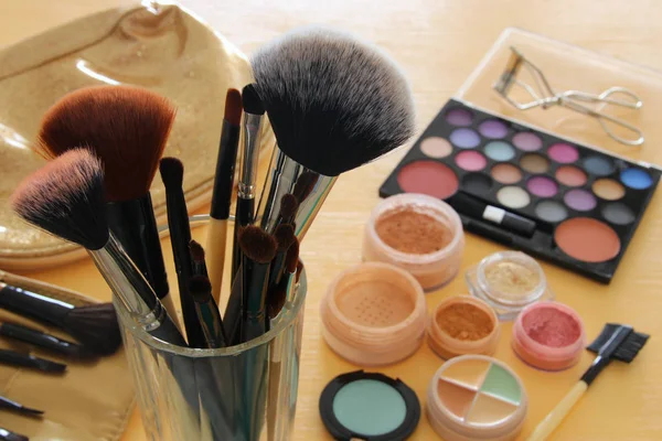 Trucco cosmetici strumenti di bellezza e spazzole su sfondo di legno — Foto Stock