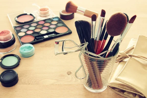 Maquillage cosmétiques outils de beauté et brosses sur fond bois — Photo