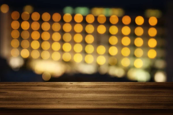 Mesa de madera frente al hotel bokeh noche. Listo para montajes de exhibición de productos —  Fotos de Stock