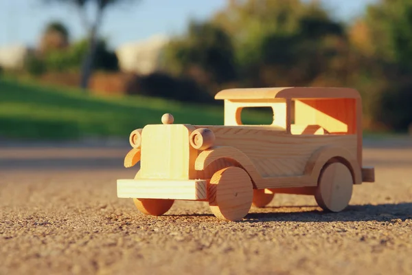 Staré dřevěné autíčko na silnici venku v parku při západu slunce — Stock fotografie