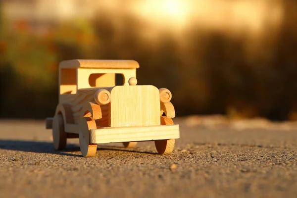 야외에서 일몰 공원에서에서도 오래 된 나무로 되는 장난감 자동차 — 스톡 사진