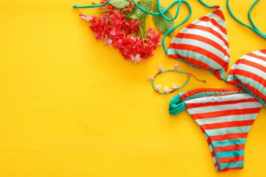 Moda bayan mayo bikini üst görünümden sarı ahşap zemin üzerine