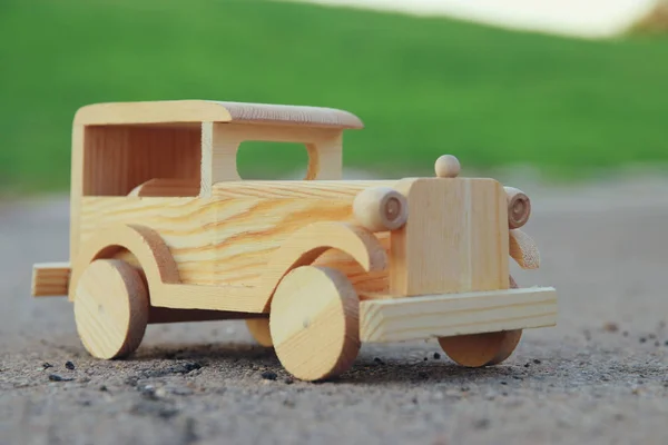 Oude houten speelgoedauto op de weg buiten in het park — Stockfoto
