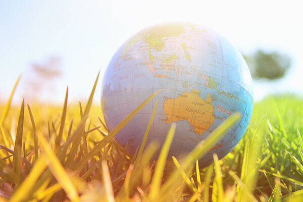 low angle of small globe in the grass. travel and global concept