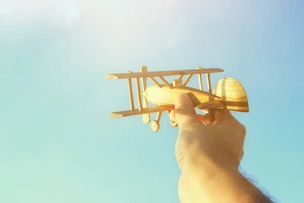 Gros plan de la main de l'homme tenant l'avion jouet contre le ciel bleu — Photo
