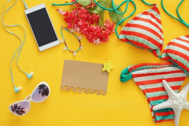 Moda bayan mayo bikini üst görünümden sarı ahşap zemin üzerine