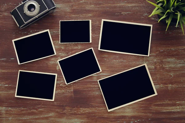 Top view of blank photo frames on wooden background — Stock Photo, Image