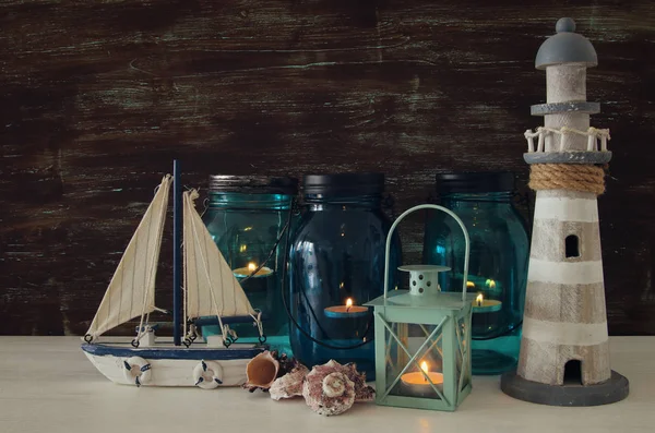 Magical mason jars whith candle light and wooden boat on the shelf. Nautical concept — Stock Photo, Image