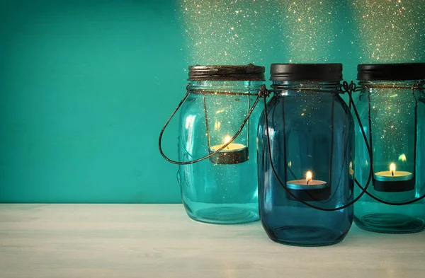 Vintage dekorativ magiska mason jars med levande ljus på träbord — Stockfoto