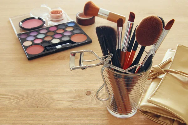 makeup cosmetics beauty tools and brushes on wooden background