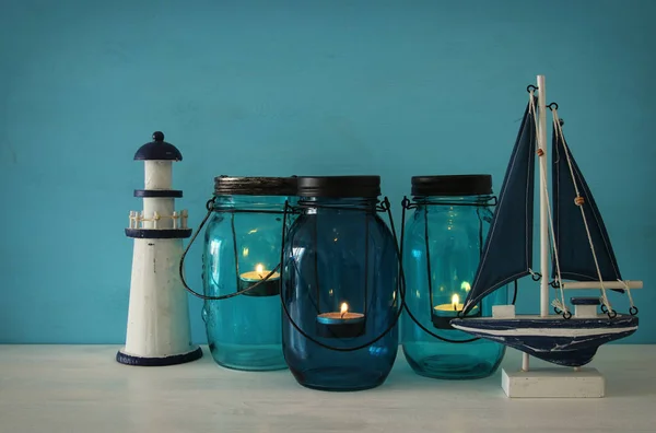 Magische mason jars whith kaars licht en houten boot op de plank — Stockfoto