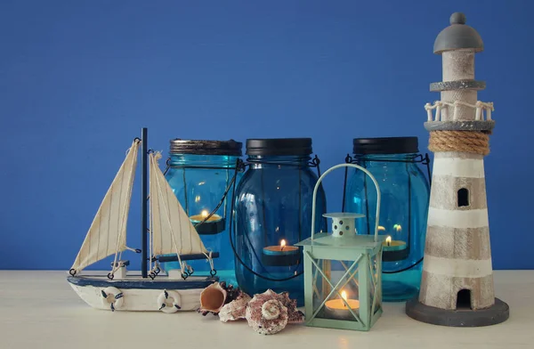 Pots magiques de maçon avec lumière de bougie et bateau en bois sur l'étagère. Concept nautique — Photo