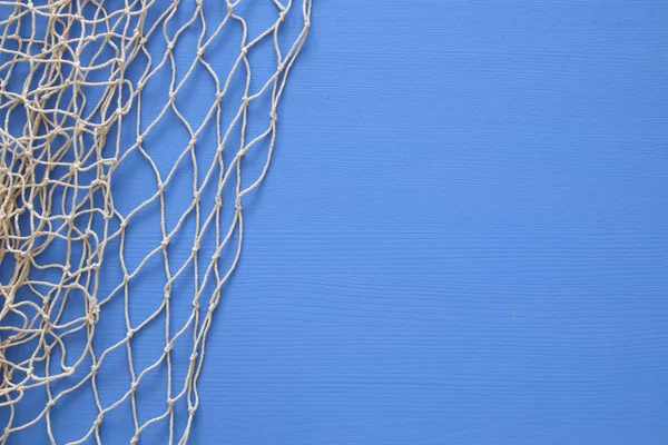 青い木製の背景を網タイツの上から見る — ストック写真