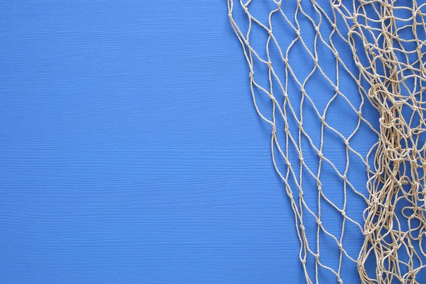 Vista superior de Fishnet sobre fondo de madera azul — Foto de Stock