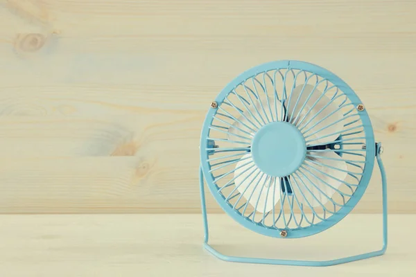 Image of blue retro fan on white wooden table. Vintage filtered — Stock Photo, Image