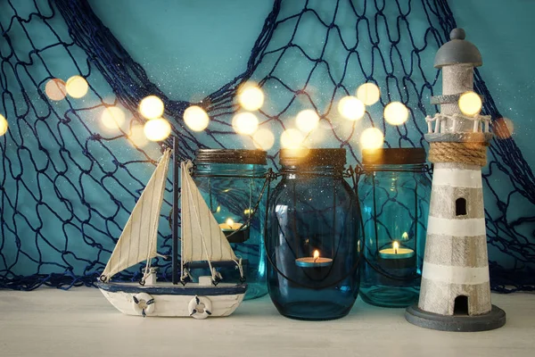 Frascos mágicos de albañil con luz de vela y barco de madera en el estante. Superposición de purpurina — Foto de Stock