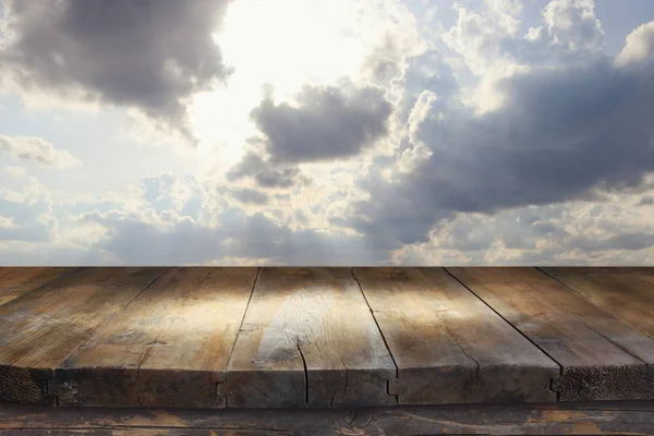 Holzbretttisch vor dem wolkenverhangenen Himmel. Hintergrund zur Produktpräsentation — Stockfoto