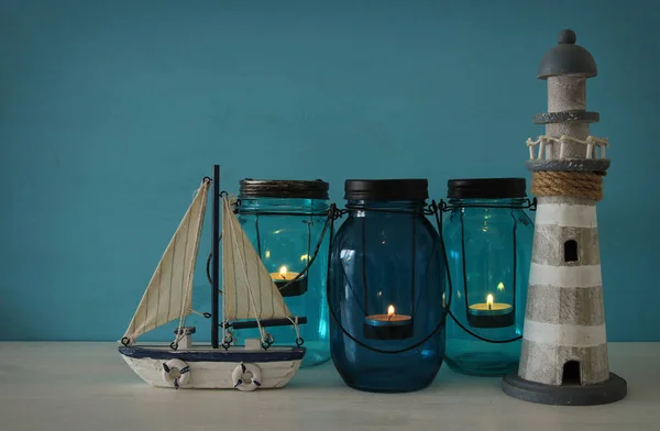 Frascos mágicos pedreiro whith vela luz e barco de madeira na prateleira. Conceito náutico — Fotografia de Stock