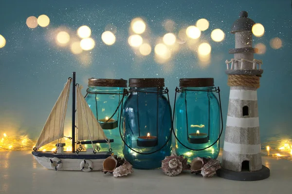 Magische mason jars whith kaars licht en houten boot op de plank. Nautische concept — Stockfoto