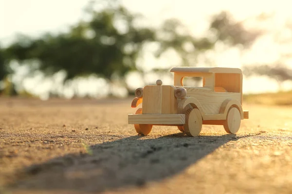 Altes Holzspielzeugauto auf der Straße im Park bei Sonnenuntergang — Stockfoto