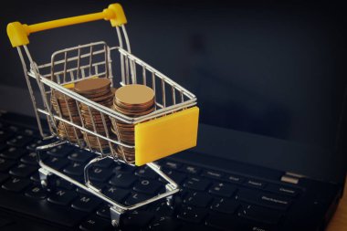 bir arabası, dizüstü bilgisayar klavyesindeki sikke yığını. para ya da online, elektronik ticaret kavramı alışveriş yapmak