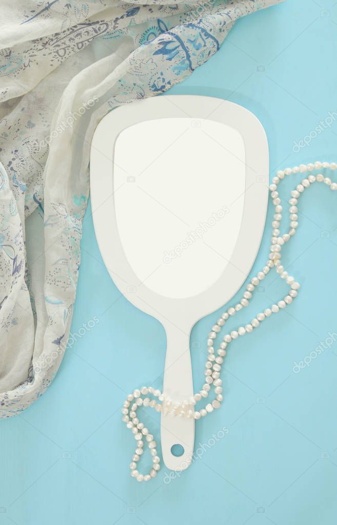Top view image of vintage hand mirror and delicate female romantic scarf