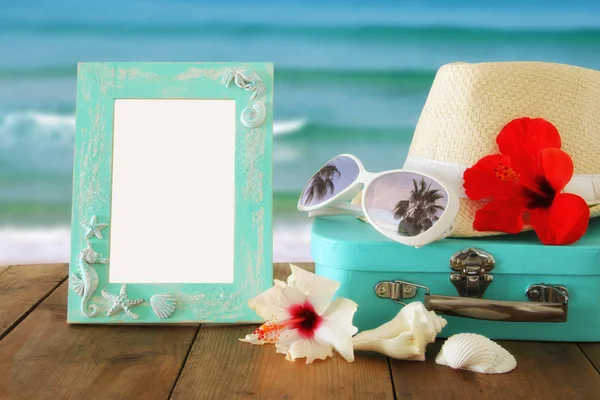フェドーラ帽、木製のテーブルとビーチの上の空白の枠の横にある熱帯のハイビスカスの花の風景の背景 — ストック写真