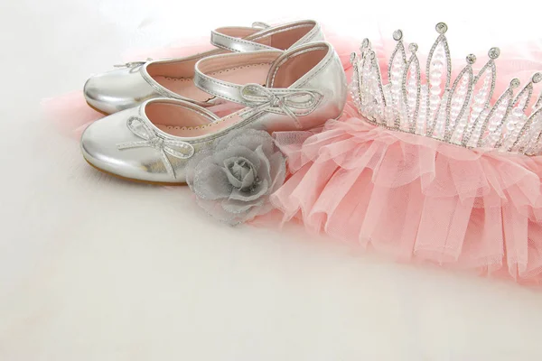 Vintage tulle pink chiffon dress, crown and silver shoes on wooden white floor — Stock Photo, Image