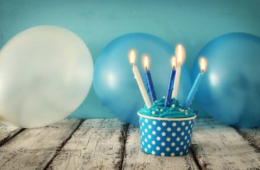 Doğum günü kavramı cupcake ve ahşap masa üzerinde mum.