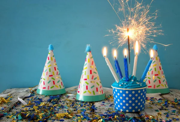 Концепция дня рождения с кексом и свечами на деревянном столе — стоковое фото