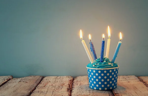 Verjaardag concept met cupcake en kaarsen op de houten tafel. — Stockfoto