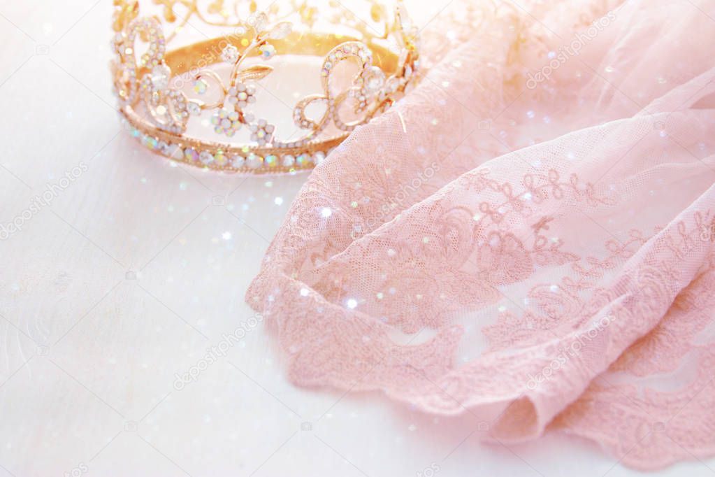 Vintage tulle pink chiffon dress and diamond tiara on wooden white table. Wedding and girl's party concept