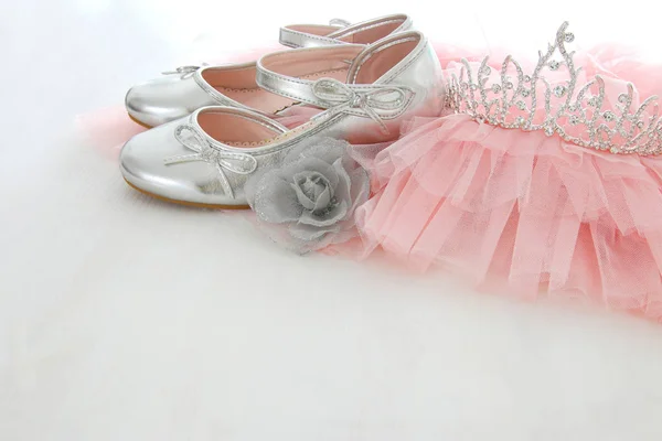 Vintage tulle pink chiffon dress, crown and silver shoes on wooden white floor — Stock Photo, Image