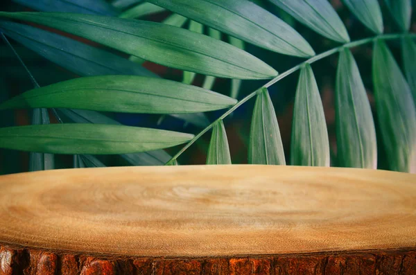 Meja kayu di depan latar belakang bunga hijau tropis. untuk tampilan produk dan presentasi — Stok Foto