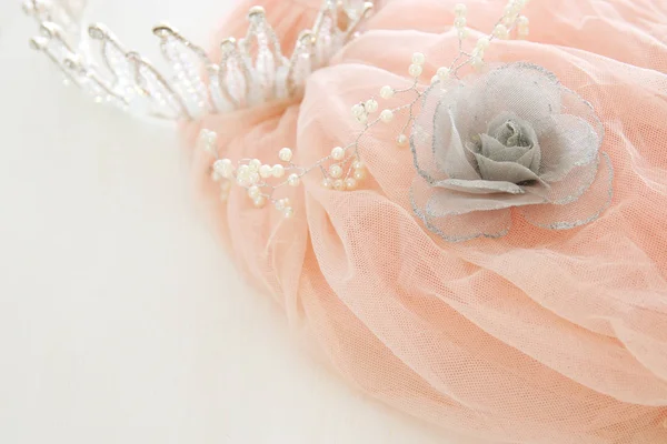 Vestido de tul vintage de gasa rosa y tiara de diamantes en mesa blanca de madera. Boda y concepto de fiesta de niña —  Fotos de Stock