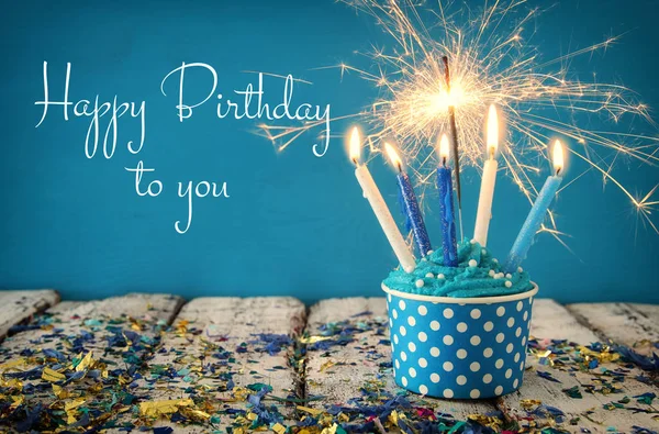 Conceito de aniversário com cupcake e velas na mesa de madeira — Fotografia de Stock
