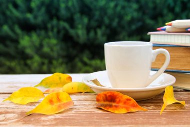 kahve fincanı ahşap masa ve arka plan önünde sonbahar yaprakları