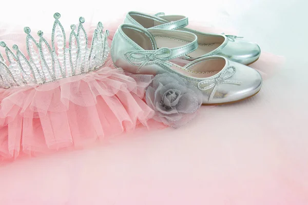 Винтажное тюль розовое шифон платье, корона и серебряная обувь на деревянном белом полу — стоковое фото