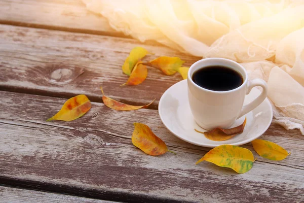 Εικόνα του φλιτζάνι καφέ πάνω από το ξύλινο τραπέζι και φθινοπωρινά φύλλα — Φωτογραφία Αρχείου