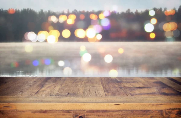 Mesa de madera vintage frente a la foto abstracta del lago brumoso y nebuloso en la mañana / noche . —  Fotos de Stock