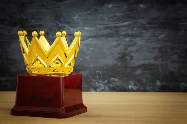 Imagen de la corona de oro premio sobre mesa de madera —  Fotos de Stock