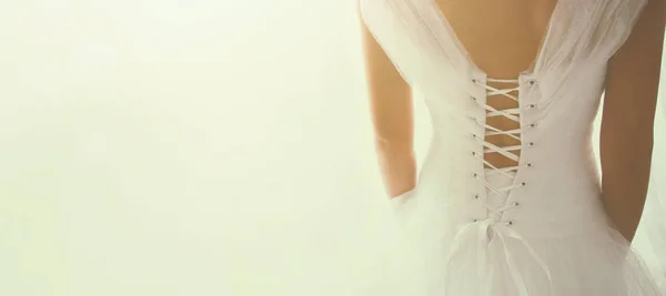 Красивая невеста со свадебным платьем и вуалью, сзади — стоковое фото