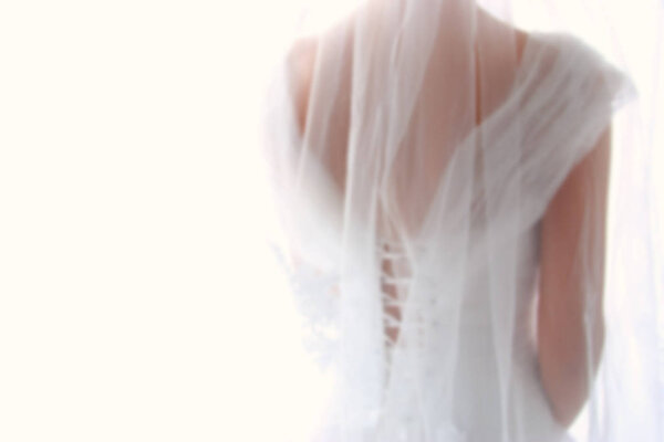 Dreamy abstract and blurry background of beautiful bride with wedding dress, from behind.
