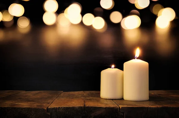 Queimando velas sobre mesa de madeira velha com luzes bokeh — Fotografia de Stock