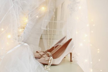 Güzel beyaz gelinlik ve peçe sandalyede altın garland ışıkları ile