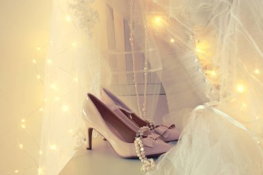 Güzel beyaz gelinlik ve peçe sandalyede altın garland ışıkları ile